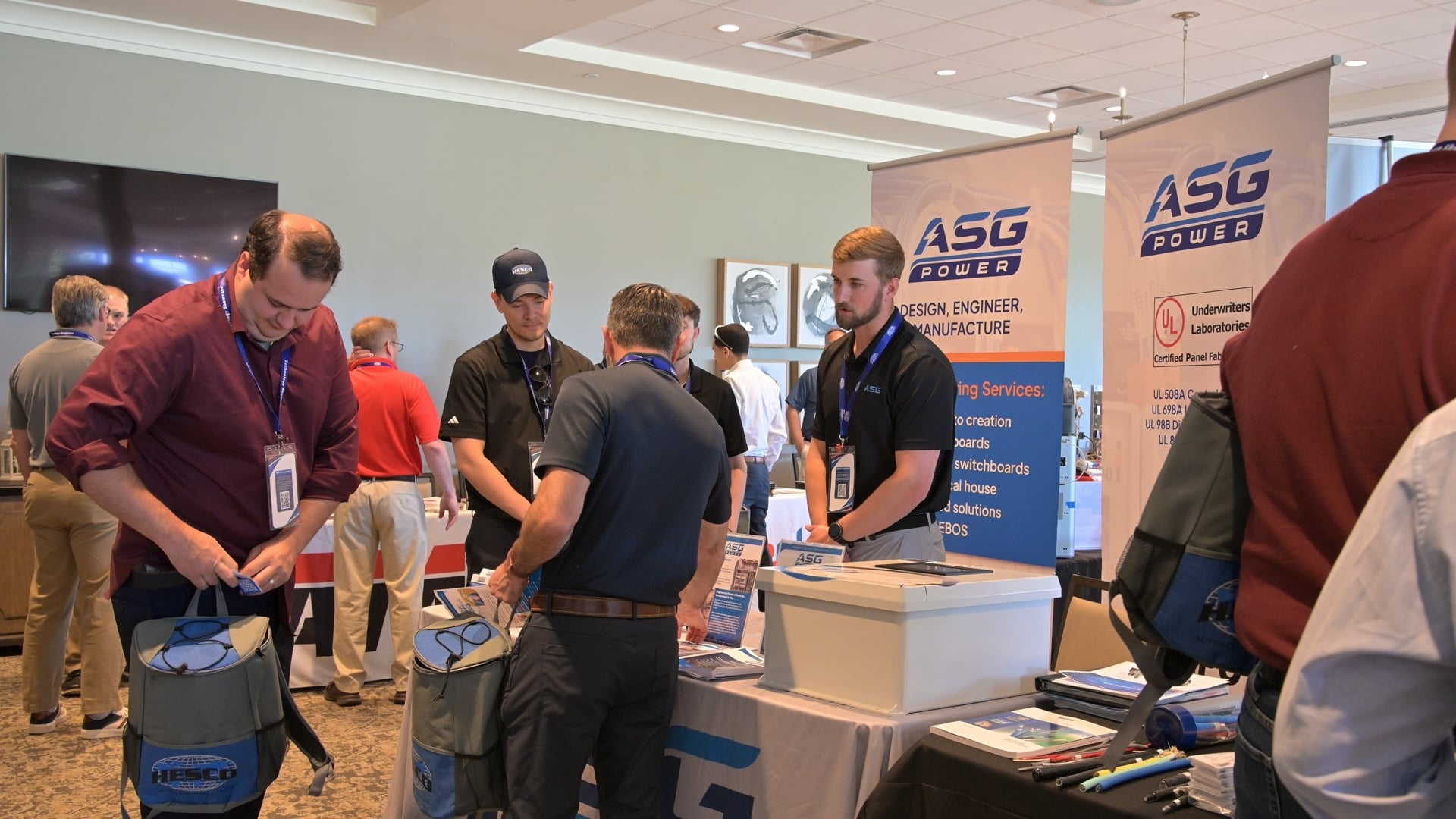 A vendor representative talks with attendees at a partner booth during the HESCO Technology Showcase